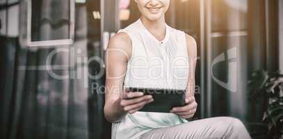 Smiling woman using digital tablet in office