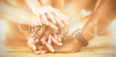 Business people putting their hands together on table
