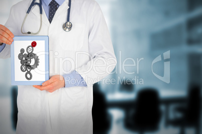 Composite image of doctor showing a digital tablet