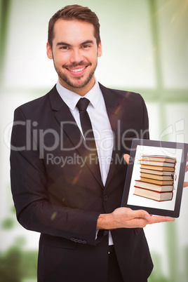 Composite image of smiling businessman showing his tablet pc