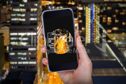 Composite image of hand holding mobile phone against white background