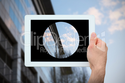 Composite image of hand holding tablet pc