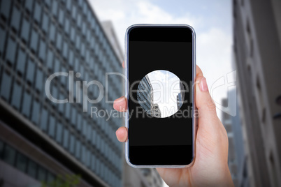 Composite image of hand holding mobile phone against white background