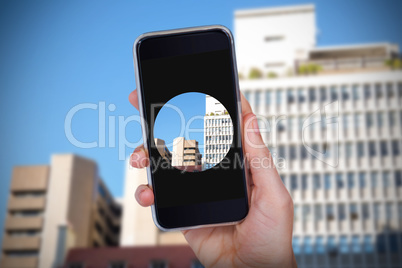 Composite image of hand holding mobile phone against white background