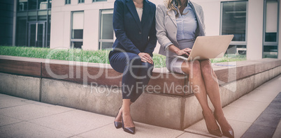 Businesswomen sitting and using laptop