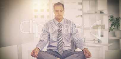 Businessman meditating on table