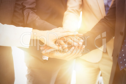 Midsection of business people stacking hands
