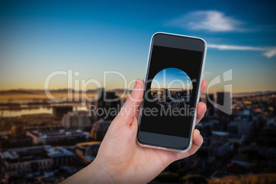 Composite image of hand holding mobile phone against white background