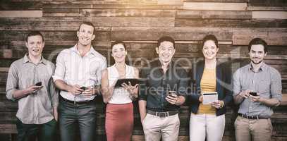 Smiling business executives using mobile phone and digital tablet