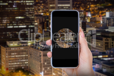 Composite image of hand holding mobile phone against white background