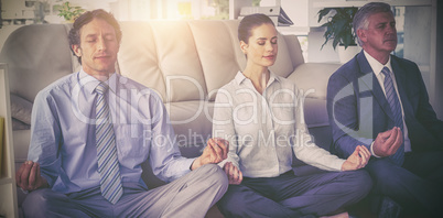 Business people meditating in lotus pose