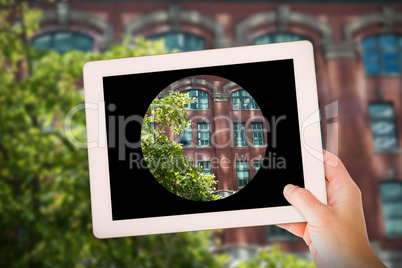 Composite image of masculine hand holding tablet