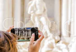 woman taking photo to Trevi Fountain in Rome