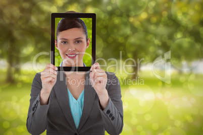 Composite image of businesswoman holding digital tablet