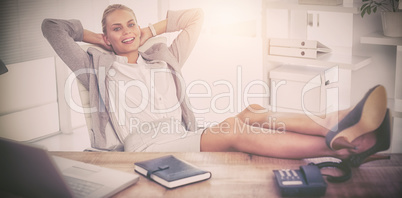 Smiling businesswoman relaxing at desk