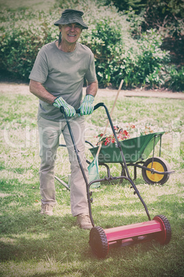 Smiling man mowing lawn