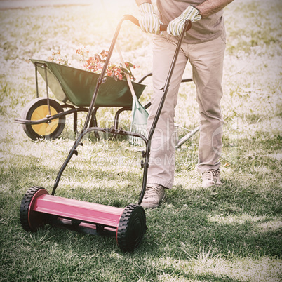 Smiling man mowing lawn