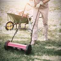 Smiling man mowing lawn