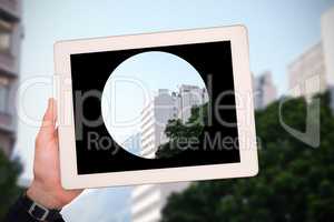 Composite image of masculine hand holding tablet