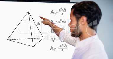Man pointing over geometric shape by formulas on board