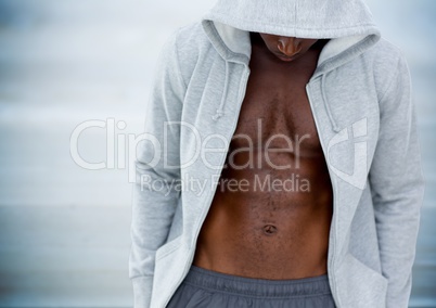 Man mid section with hoodie and head down against blurry blue wood panel