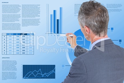 Rear view of businessman making graph while working in office