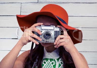 Close up of woman with camera against white wood panel