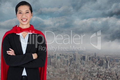 Portrait of smiling businesswoman wearing cape while standing against city