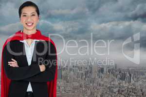 Portrait of smiling businesswoman wearing cape while standing against city
