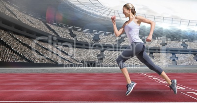 Side view of female athlete running on racing track