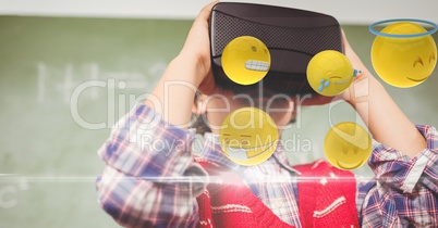 Boy looking at emojis through VR glasses