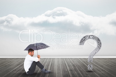 Businessman with umbrella looking at question mark on pier