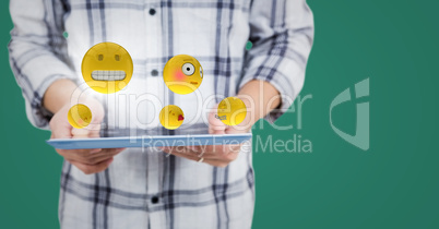 Man mid section with tablet, emojis and flare against teal background