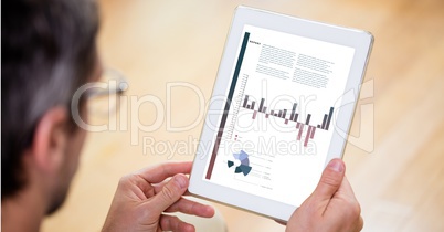 Businessman analyzing graphs on digital tablet