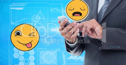 Digitally generated image of businessman using smart phone with emoji tech graphics