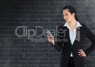 Businesswoman on phone against dark wall