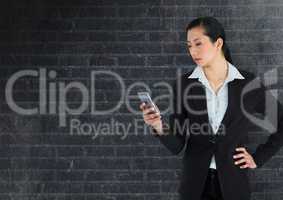 Businesswoman on phone against dark wall