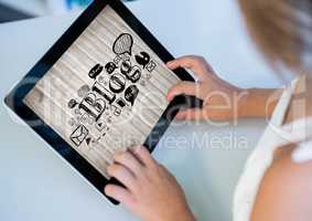 Woman with tablet showing black blog doodles against blurry wood panel