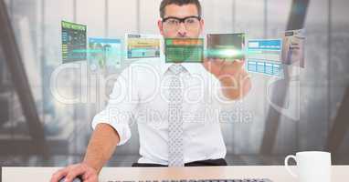 Digitally generated image of businessman touching futuristic screen while working in office