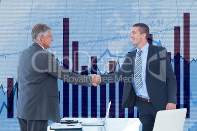 Businessmen shaking hands against graph background