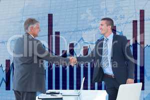 Businessmen shaking hands against graph background