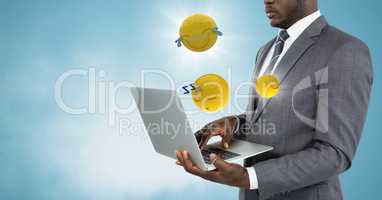 Business man with laptop and emojis with flares against blue background with cloud