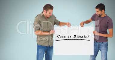 Smiling men holding billboard with keep it simple text against blue background