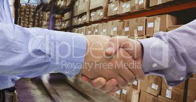 Close-up of business people shaking hands in warehouse