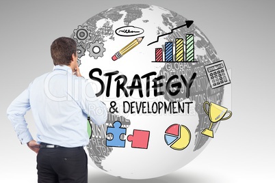 Rear view of businessman looking at strategy and development icons on globe