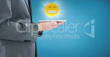 Business man mid section with tablet and emoji with flare against blue backround