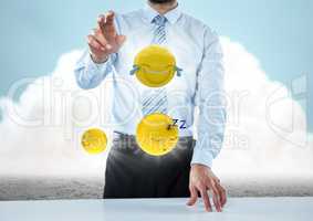 Business man at desk with emojis and flares against ground and cloud