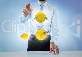 Business man at desk with emojis and flares against blue background