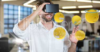 Happy man looking at emojis on VR glasses