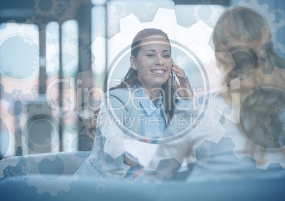 Business woman on phone behind gear graphic overlay